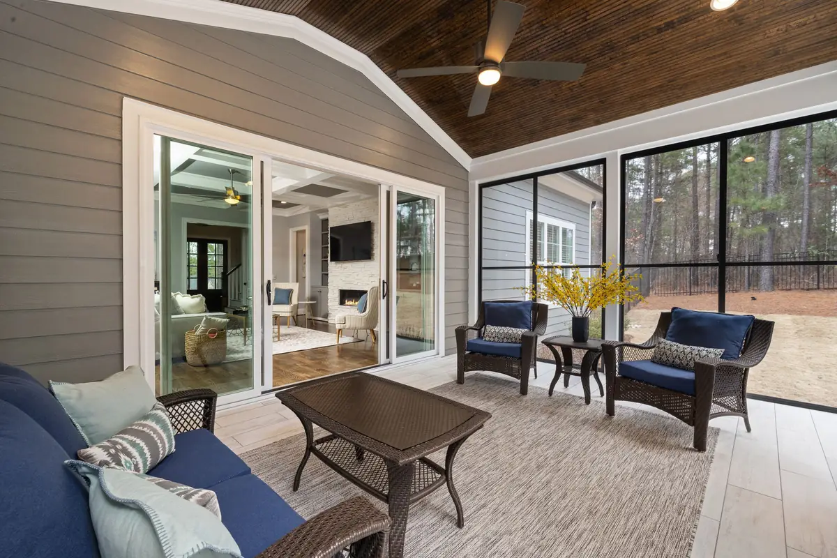 Screened porch with wicker chairs and a ceiling fan
